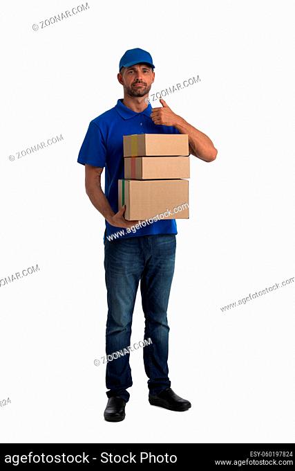 Smiling young post employee with parcels giving thumb up isolated on white background