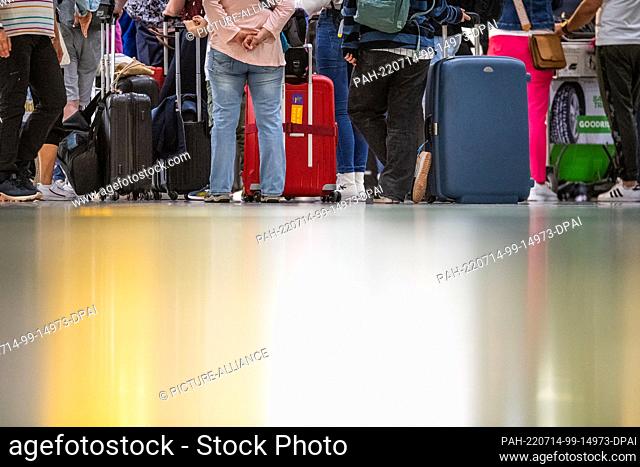 14 July 2022, Lower Saxony, Hanover: People wait at a check-in counter in the departure hall of Terminal A at Hannover Airport