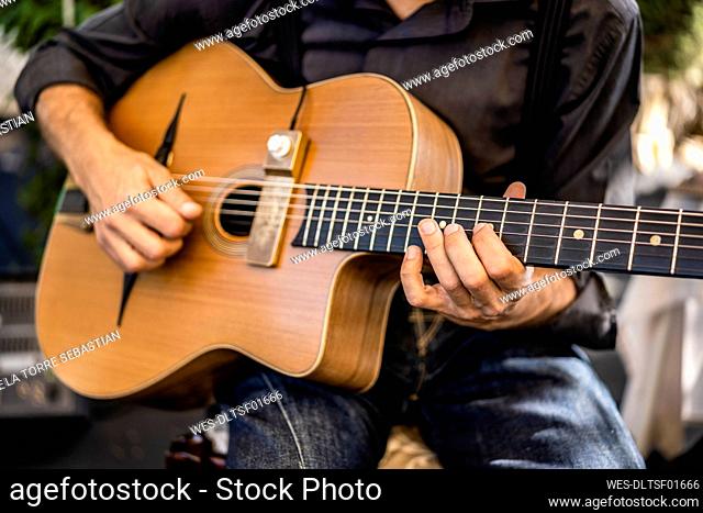 Male musician playing guitar during event