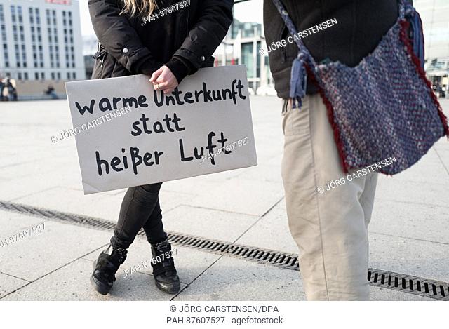 A woman holds up a sign reading 'warme Unterkunft statt heisser Luft' (lit. 'warm shelter instead of hot air') during a demonstration with the motto 'Kaeltetod...
