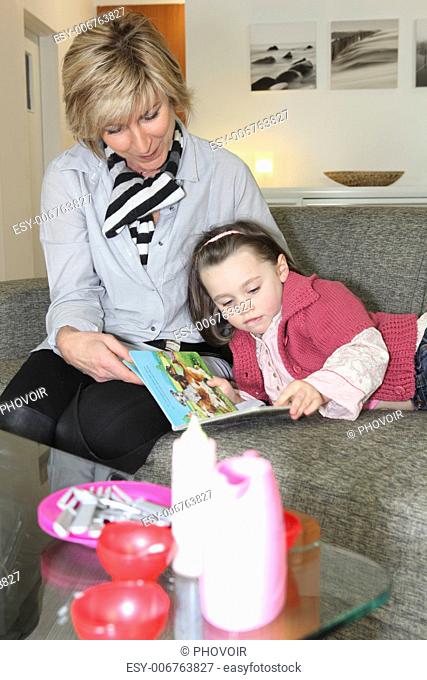 Woman and little girl reading a book