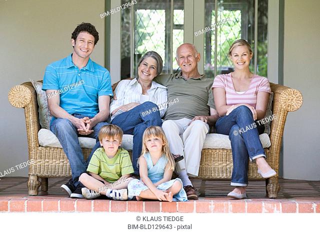 Caucasian multi-generation family smiling on porch