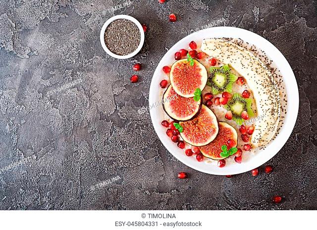 Delicious and healthy oatmeal with figs, kiwi, pomegranate, banana and chia seeds. Healthy breakfast. Fitness food. Proper nutrition. Flat lay