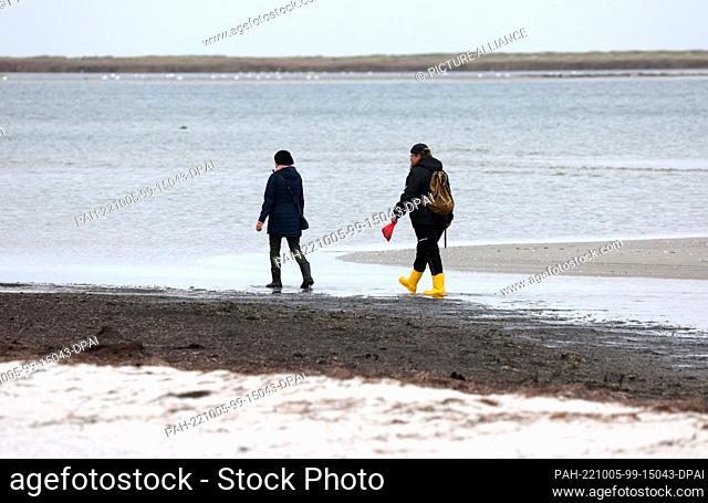 05 October 2022, Mecklenburg-Western Pomerania, Prerow: Vacationers are out and about on the Baltic Sea beach in the Vorpommersche Boddenlandschaft National...