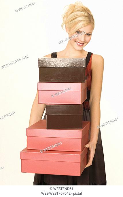 Young woman with stack of shoeboxes, portrait