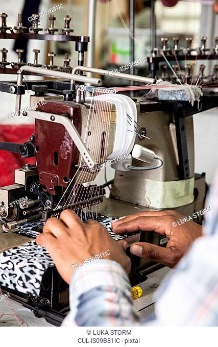Person working on industrial smocking sewing machine in factory, Cape Town, South Africa