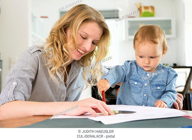 Baby girl drawing with mother