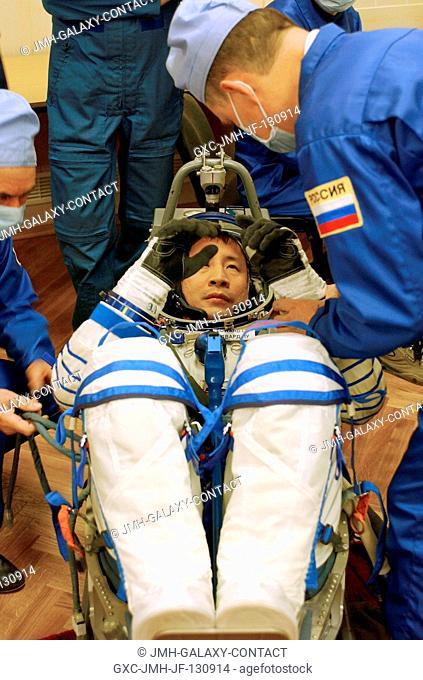 Astronaut Edward T. Lu, Expedition Seven NASA ISS science officer and flight engineer, has a leak check performed on his Russian Sokol suit in the Soyuz...