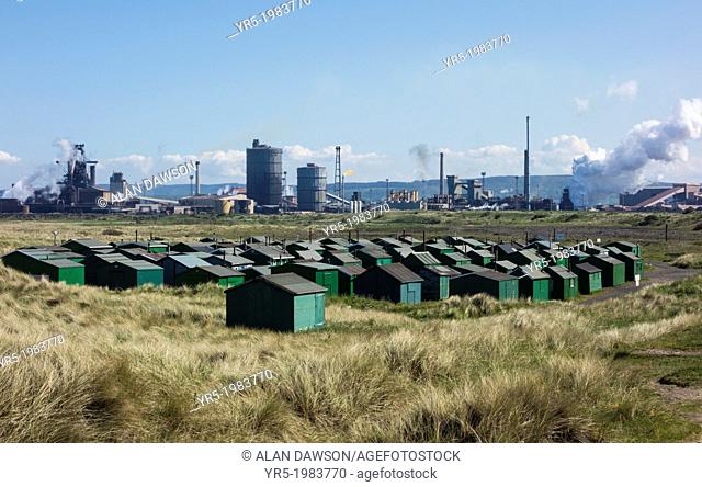 Fishermens huts at the South Gare with steelworks in background. Redcar, north east England, United Kingdom
