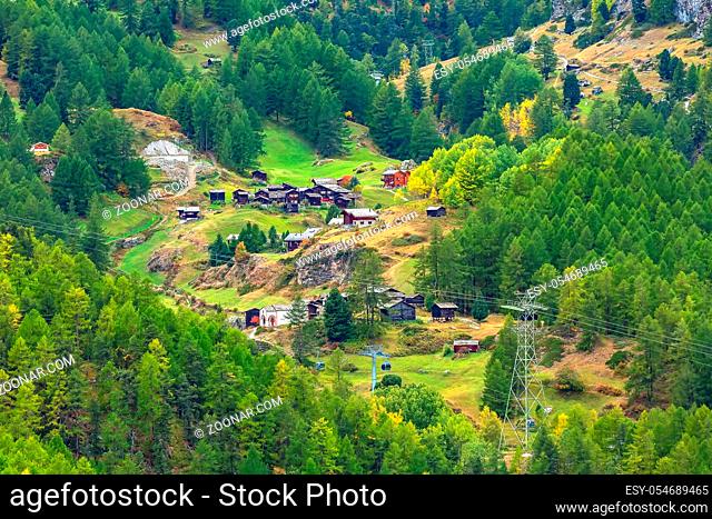 Beautiful alpine village in the pine woods, Switzerland, Swiss Alps near Zermatt and cable car cabins