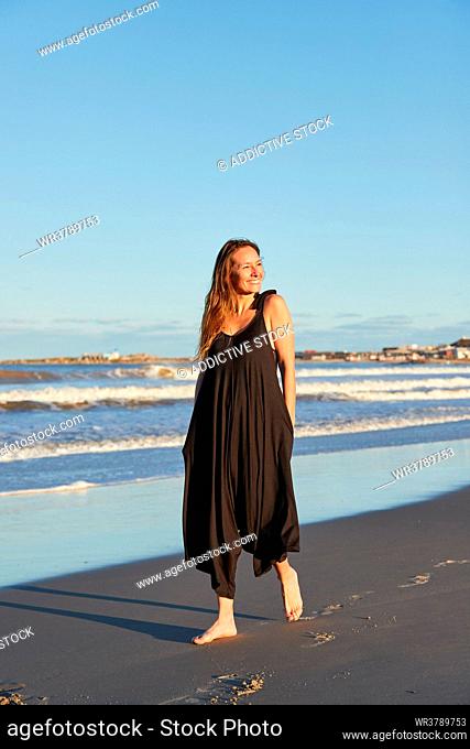 young woman, happy, barefoot, beach walking