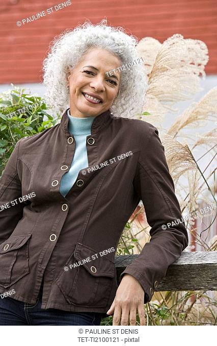 Woman leaning against fence