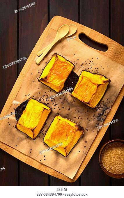 Baked pumpkin pieces with caramelized sugar on top, a traditional autumn snack in Hungary, photographed overhead on dark wood with natural light