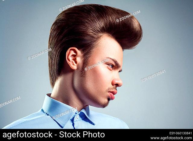 Side view of young man with retro classic pompadour hairstyle. studio shot