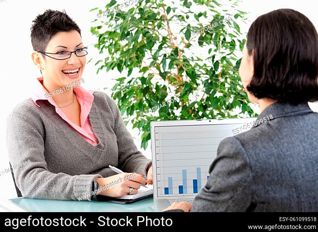 Young businesswomen having a business meeting, discussing business chatrs on laptop computer