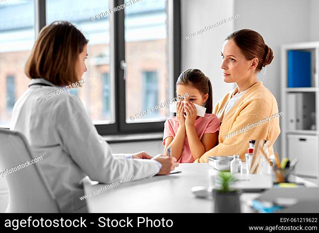 mother, daughter blowing nose and doctor at clinic