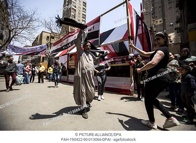 22 April 2019, Egypt, Cairo: Voters sing and dance outside a polling station during the third and last day of the national referendum on the constitutional...
