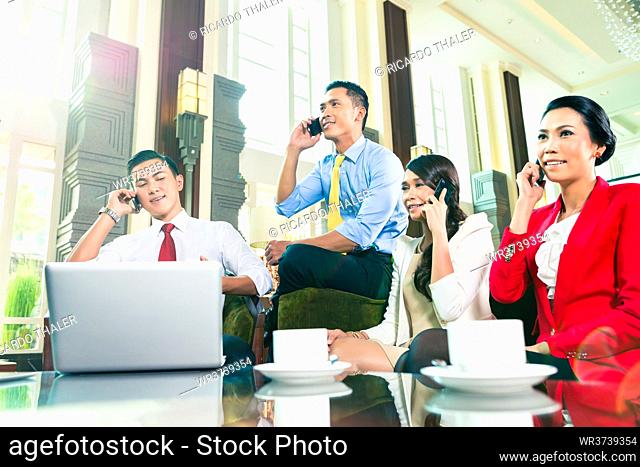 Asian Businesspeople talking on cell phone