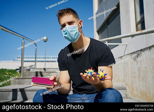 Caucasian male in medical masks with virus mock-ups and passport. Concept of not being able to travel and move around the coronavirus