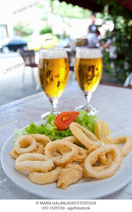 Fried squids serving and two glasses of beer in a terrace. Madrid, Spain