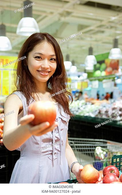 Young woman buying fruit in supermarket