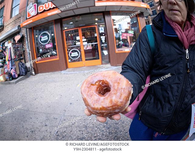 A donut aficionado holds the newly released Dunkin Donuts' ''Croissant Donut'' in New York. The 300 calorie pastry is the chain's attempt to capitalize on the...
