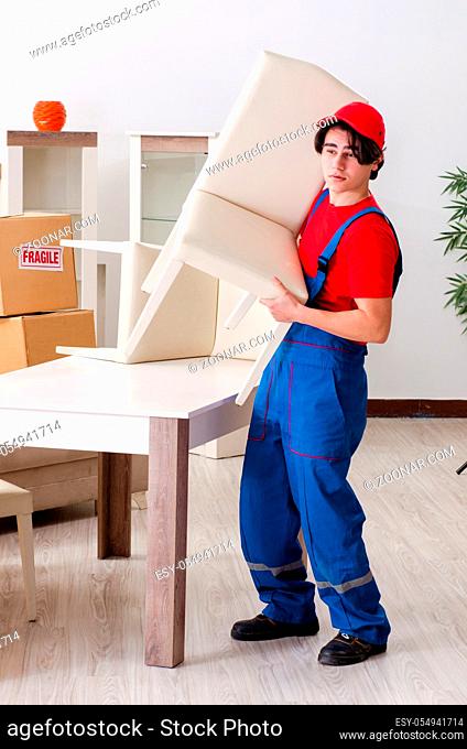 Young male contractor with boxes working indoors