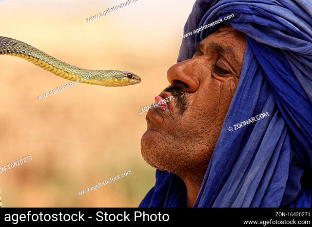 Ouarzazate, Morocco - July 27, 2015 : Unidentified snake charmer plays with the snake for tourists in Ouarzazate, Morocco