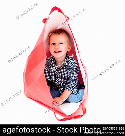 Cute little boy inside a red packet. Concept of own toy house