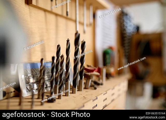 Closeup selective focus on hard metal drill bit set at professional carpentry workshop for woodworking, repair and renovation