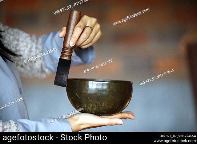 Tibetan singing bowl, buddhist instrument used in sound therapy, meditation and yoga. Bowl in the hands of prayer. Vietnam