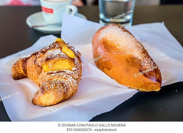 Syracuse in Sicily, Italy. Traditional fresh brioches with cream served at bar table as breackfast. Natural light, no studio