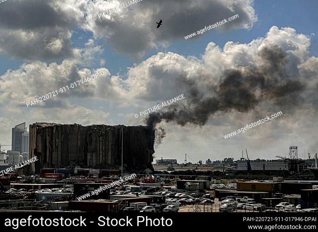 21 July 2022, Lebanon, Beirut: Heavy black smoke billows from devastated Beirut port wheat silos, where nearly two years ago an explosion killed more than 200...