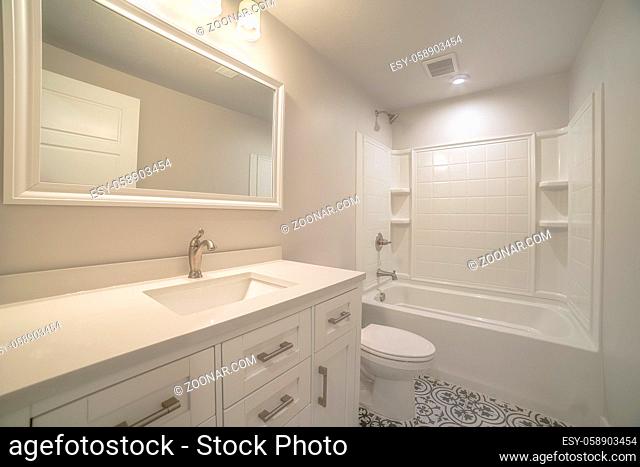 Modern fitted white bathroom interior with empty shelves, vanity and toilet in a new house