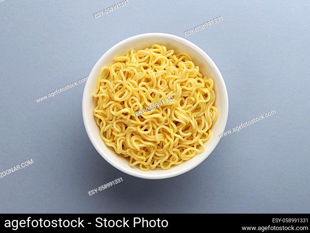 Instant noodles in white plate with copy space, top view