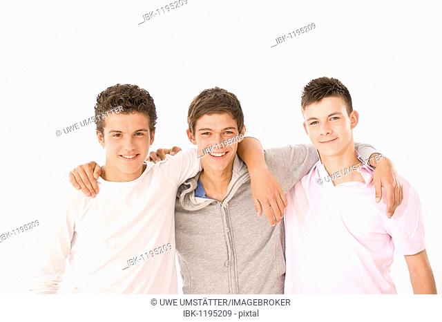 Three boys standing next to each other, arm in arm