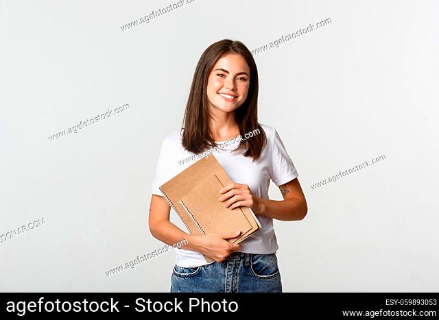 Happy smiling girl student holding notebooks, apply for courses or university
