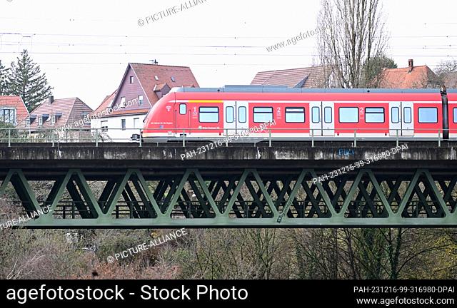 PRODUCTION - 15 December 2023, Baden-Württemberg, Stuttgart: An S-Bahn train crosses the Nesenbach viaduct in Stuttgart-Vaihingen