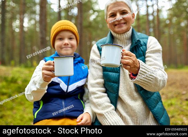 grandmother with grandson drinking tea in forest