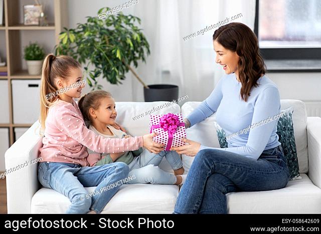 daughters giving present to happy mother