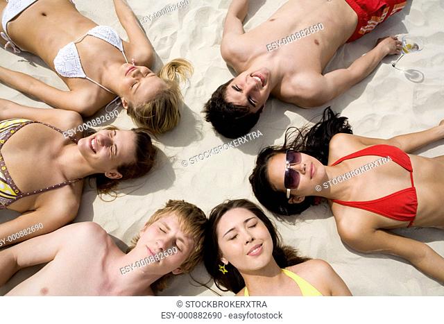 Image of six people resting on the sand