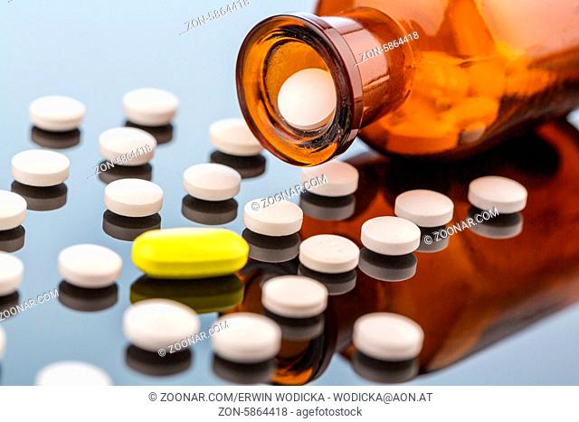Viele Tabletten mit einem Glasbeghäter. Symbolfoto für Sucht und Kosten in der Medizin und bei Medikamenten