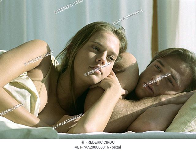 Man and woman in bed, woman leaning against man, close up