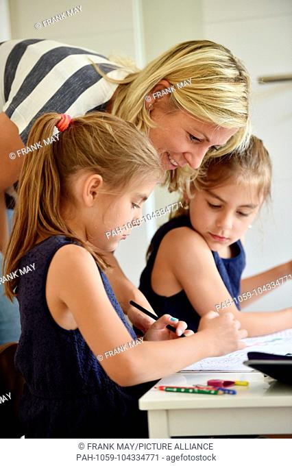 Two girl are doing their homework with the help of their mother, , Germany, city of Osterode, 23. May 2018. Photo: Frank May (model released) | usage worldwide