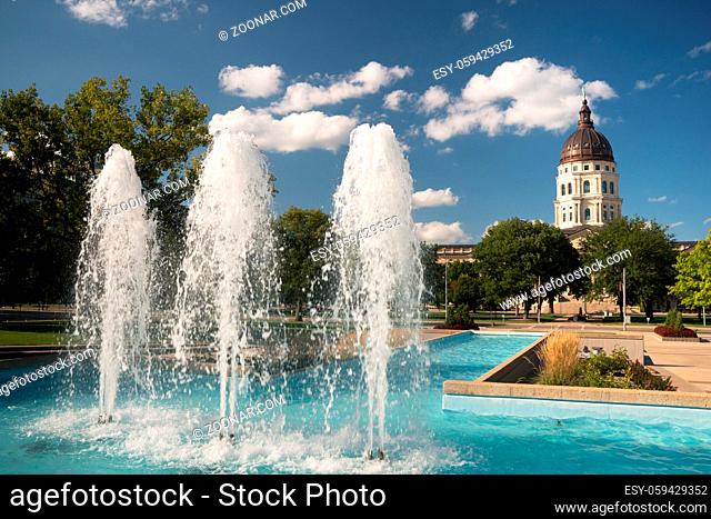 Soft clouds and blue skies appear over fountains and the capitol of Topeka, Kansas USA