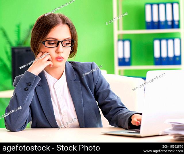 The young female employee very busy with ongoing paperwork