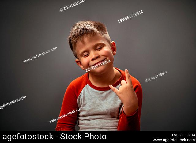 This kid rocks. Fool of satisfied emotions little boy showing ROCK gesture with happy eyes closed. Human emotions, facial expression concept