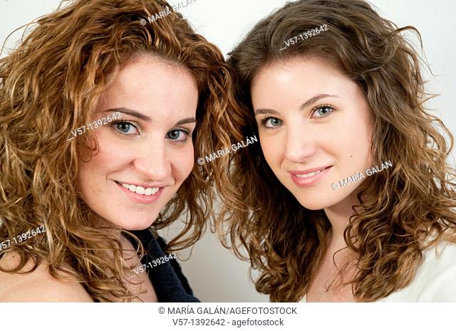 Two young women smiling and looking at the camera. Close view