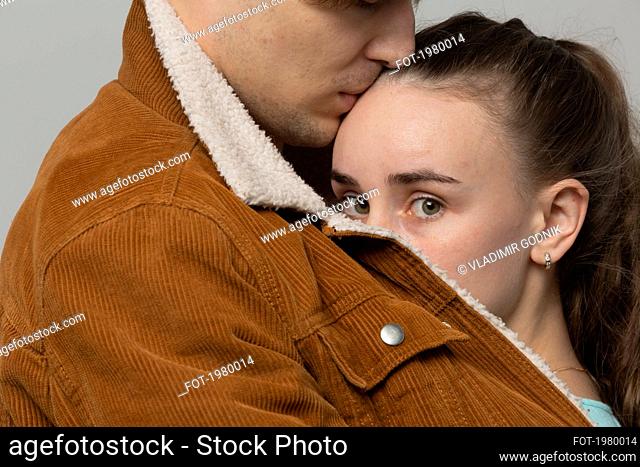 Close up portrait worried young woman in arms of boyfriend