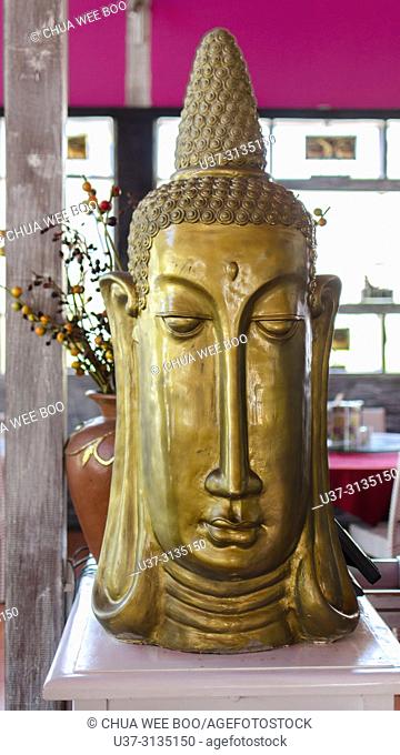 Gold Budhha face placed at a restaurant in Seminyak Street, Bali